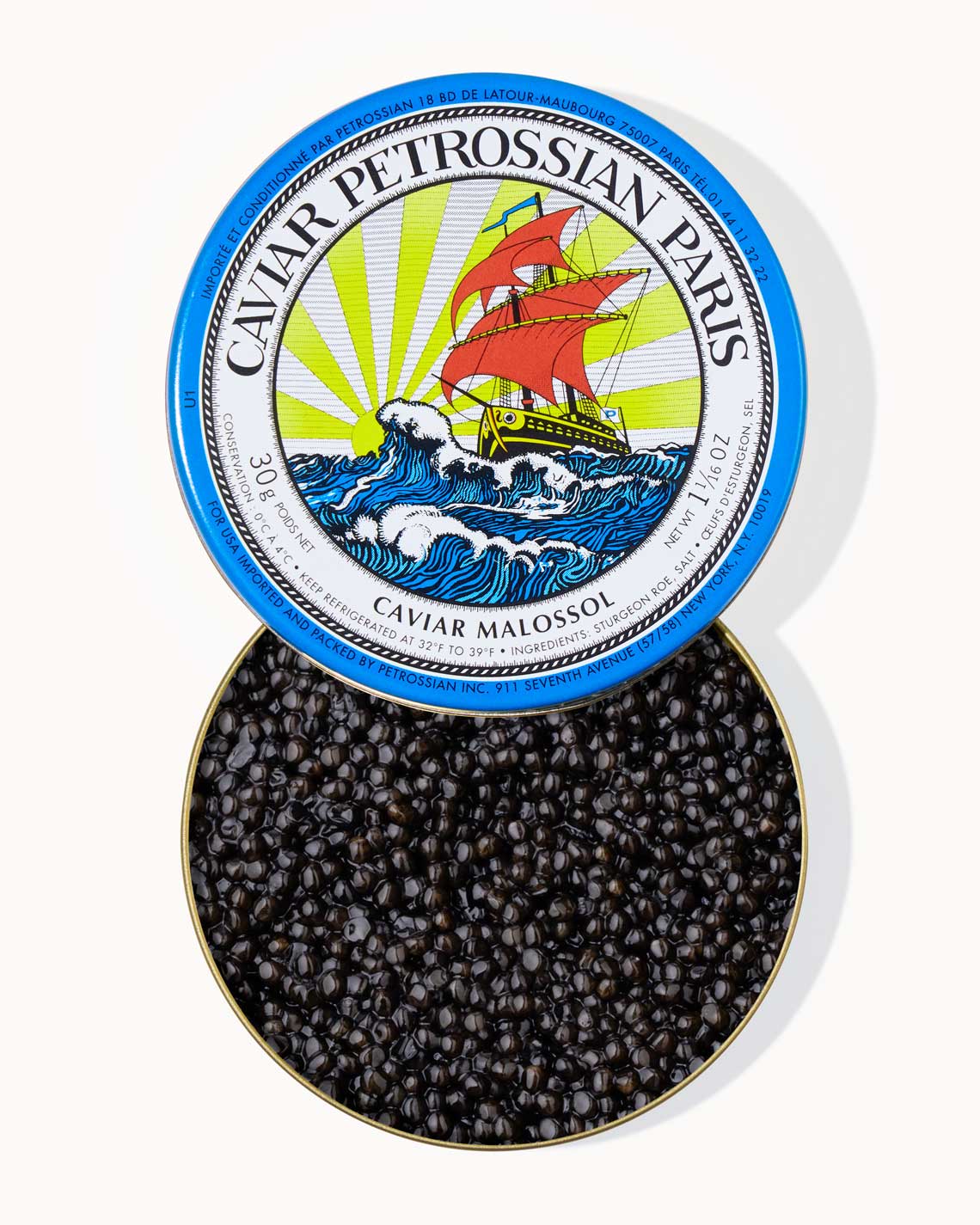 A top down image of an opened blue tin of Petrossian caviar, sitting on a white background. The tin is filled with plump, glistening black beads of baika caviar.