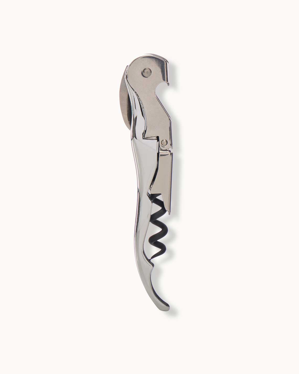 A silver metal folding corkscrew lies on a white background. It is folded and resting on its side.