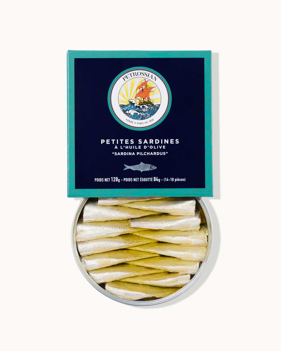 A navy and teal Petrossian box filled with an opened tin of silver sardines packed with oil