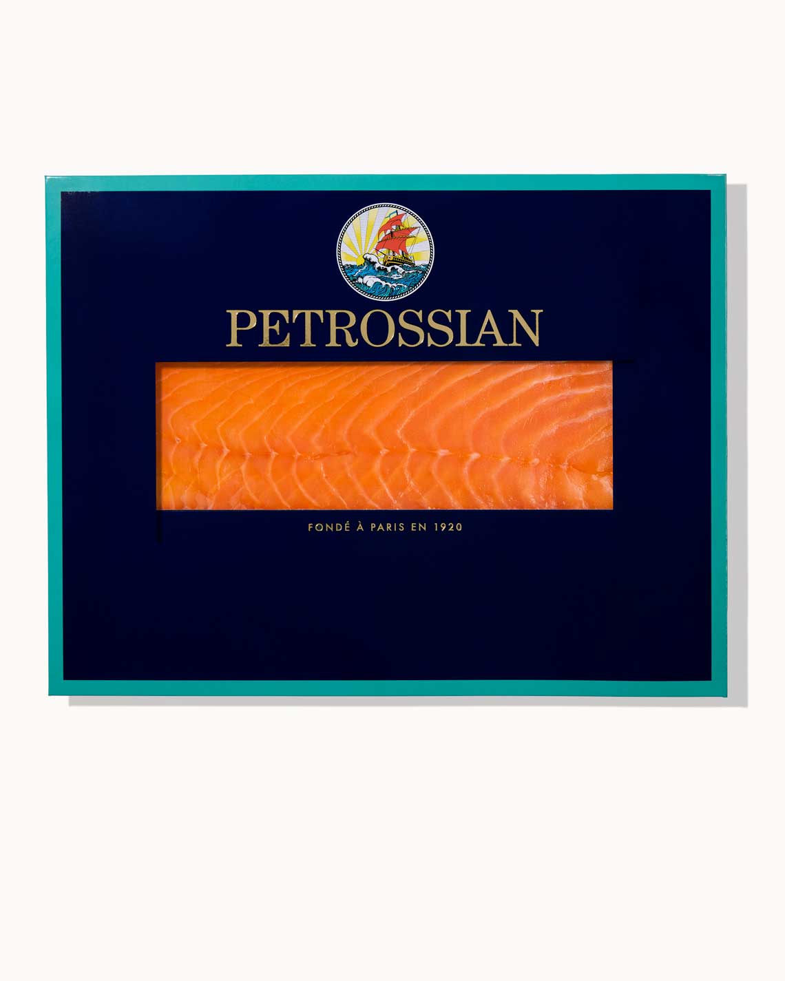 A navy blue Petrossian envelope with teal trim sits on a white background. A juicy slice of rich Smoked Salmon can be seen through a cut-out in the center of the box.