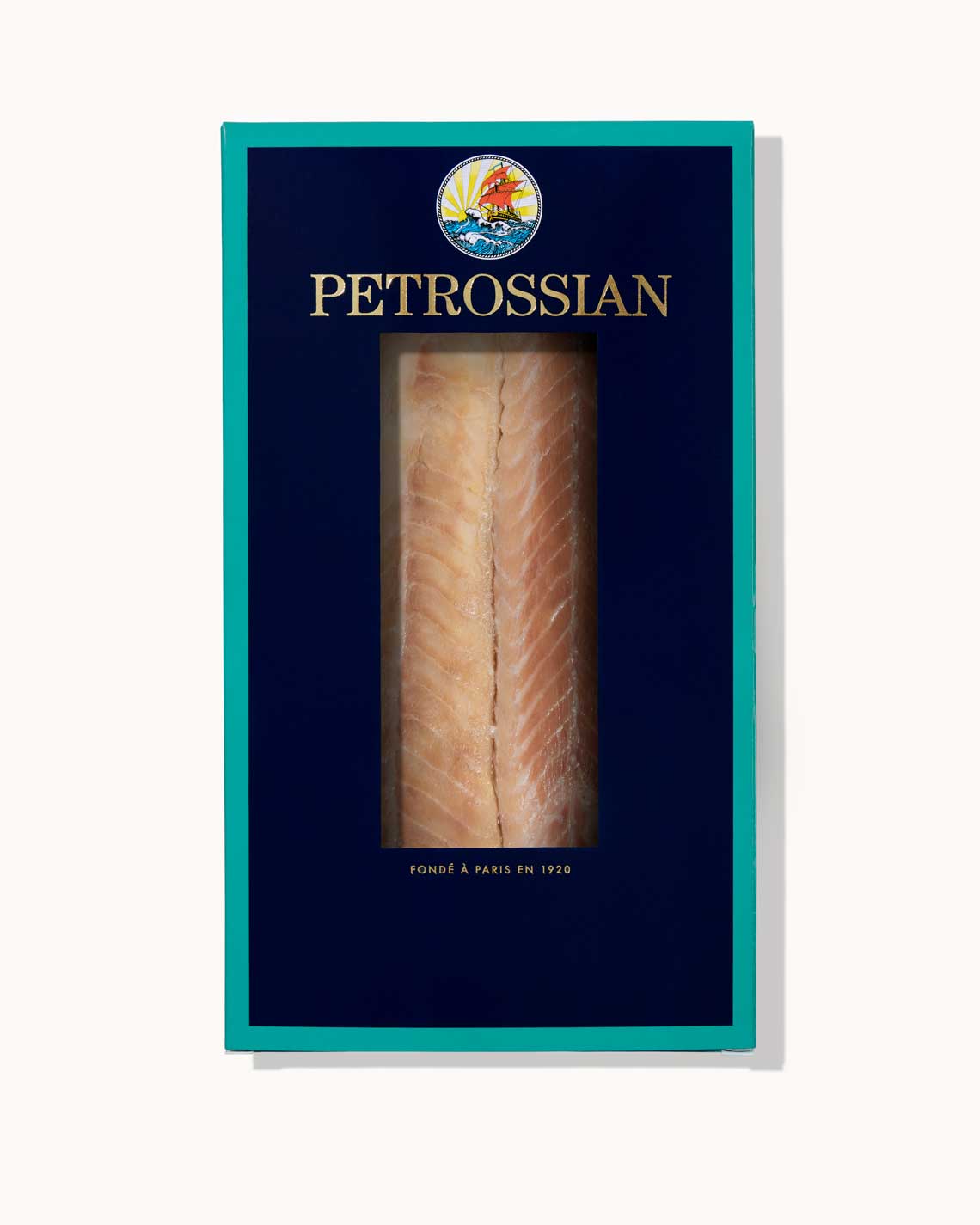 A navy blue Petrossian box with teal trim sits on a white background. A juicy filet of rich smoked eel can be seen through a cut-out in the center of the box.