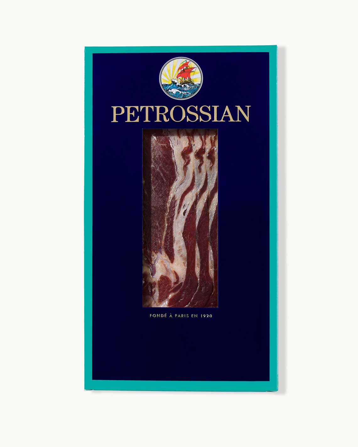 A navy and teal Petrossian box filled with long, red, fatty cuts of Spanish ham