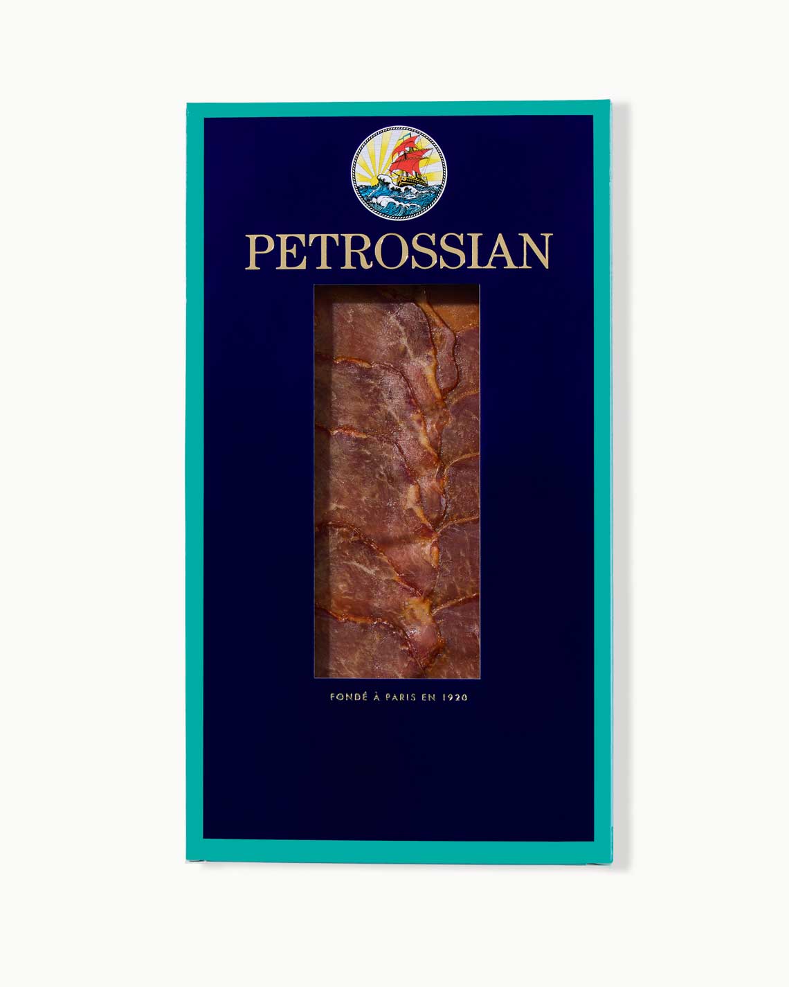 A navy and teal Petrossian box filled with dark, thick slices of pork loin