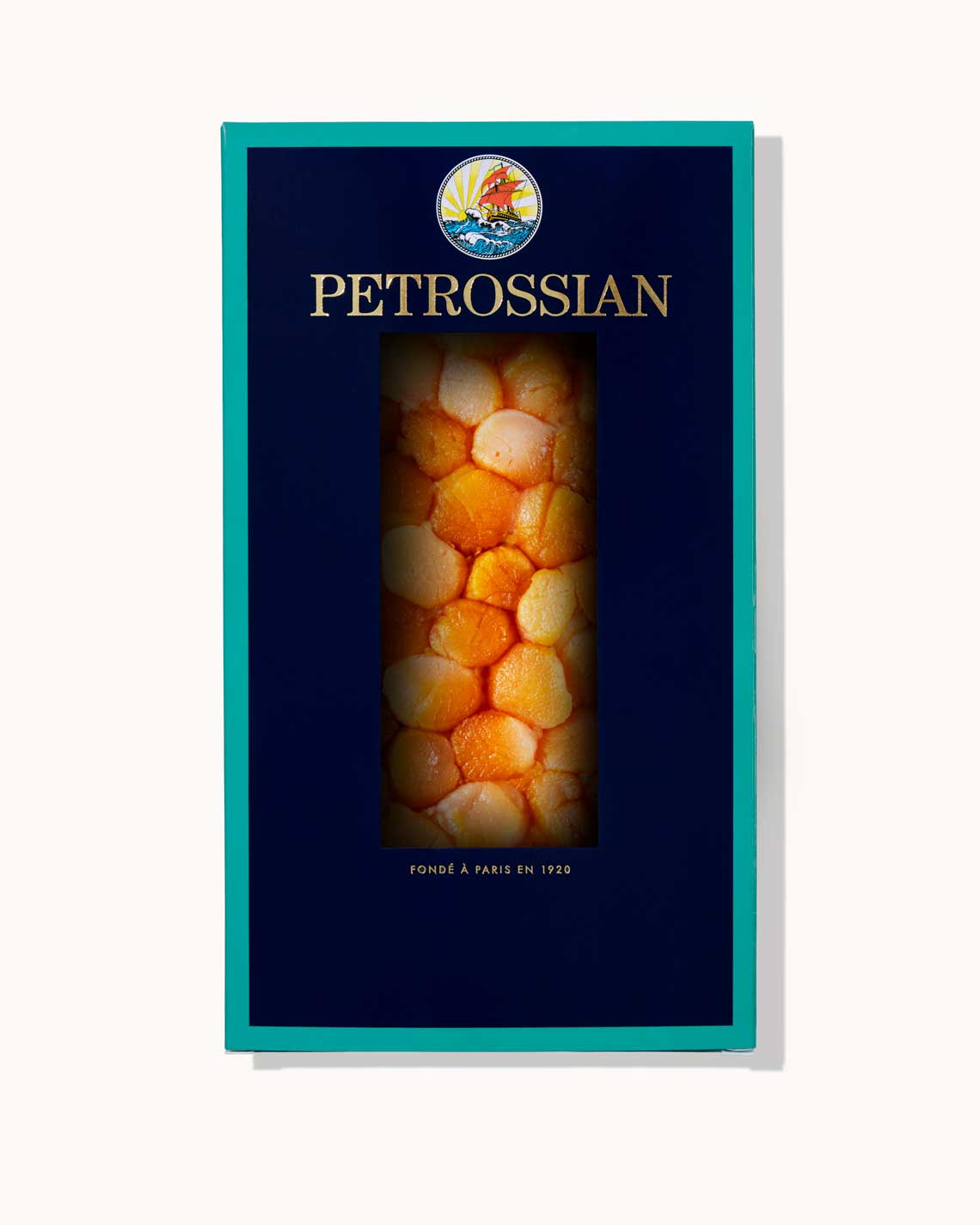 A navy blue Petrossian box with teal trim on a white background. Dozens of juicy bay scallops can be seen through a cut-out in the center of the box.
