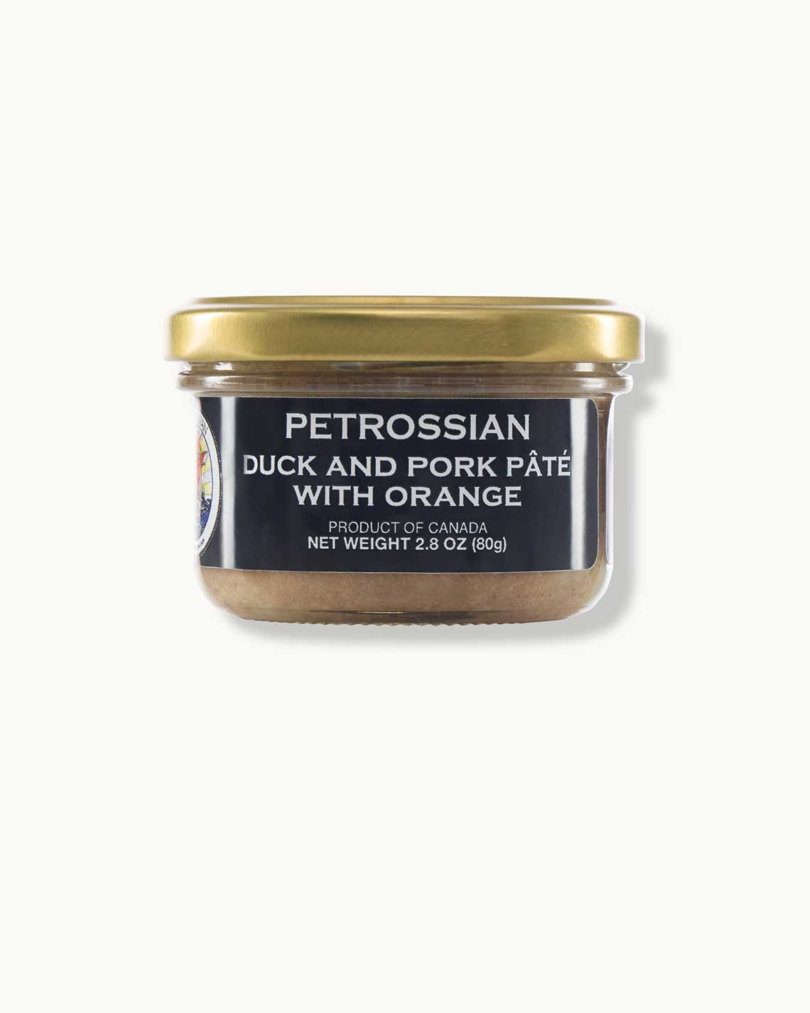 a glass jar with a coper top and a navy blue label sits on a white background. It is filled with rich duck pâté