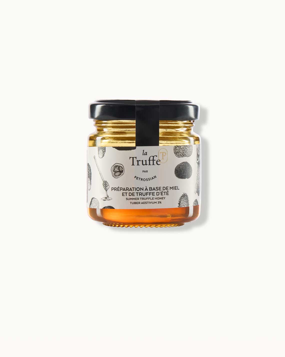 a short glass jar with a white "la Truffe" label lies on a white background. it is filled with golden truffle honey.
