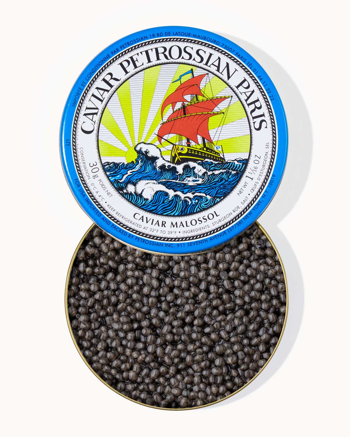 A top down image of an opened blue tin of Petrossian caviar, sitting on a white background. The tin is filled with plump, glistening slate gray beads of Beluga-Hybrid caviar.