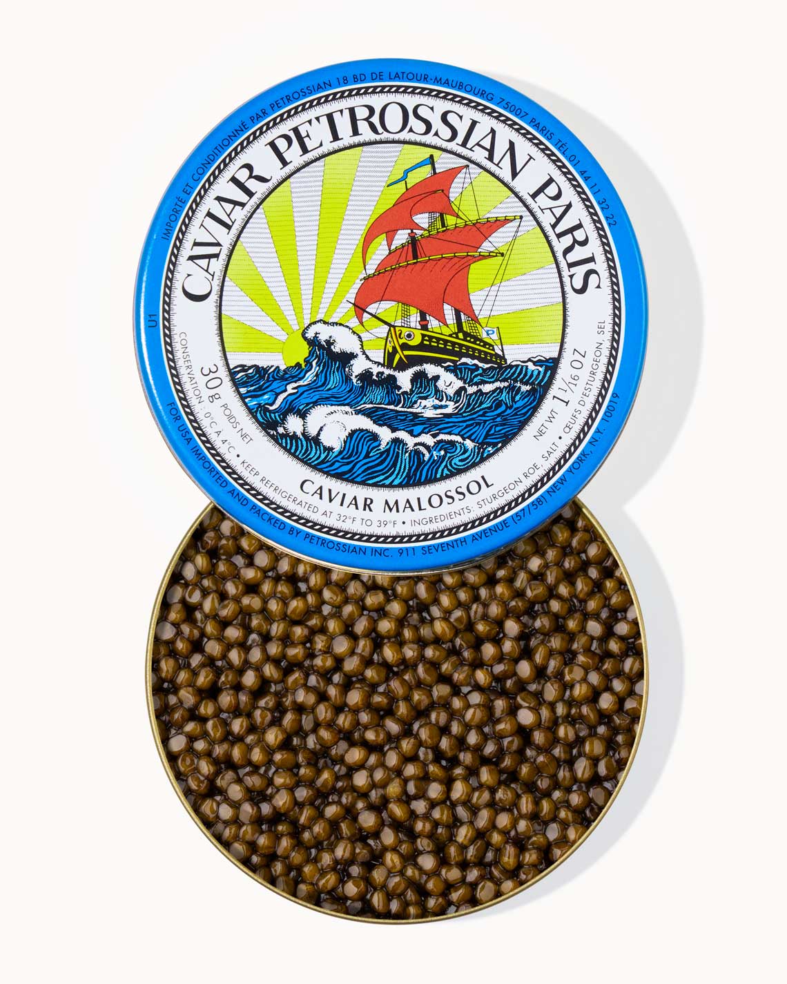 A top down image of an opened blue tin of Petrossian caviar, sitting on a white background. The tin is filled with plump, glistening bright amber Kaluga-Hybrid caviar.