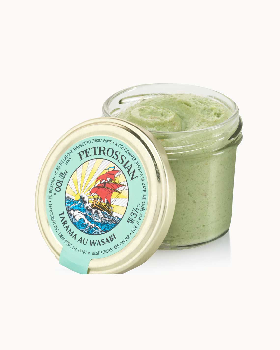 an open glass jar with a copper lid and a green label is filled with creamy wasabi tarama, sitting on a white background.