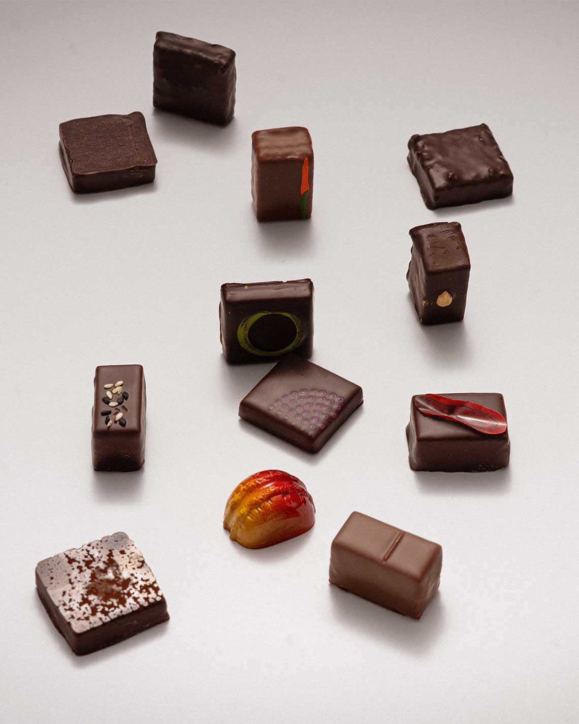 Assorted chocolate truffles on a light gray background