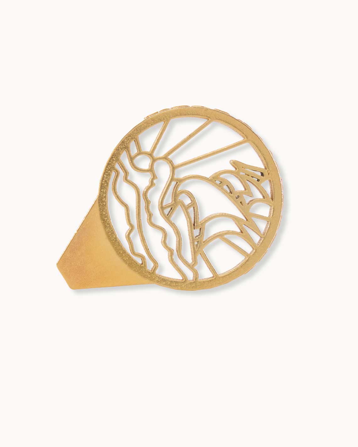 A gold-plated caviar opener, made of thick metal, sits on a white background. It is shaped to show the outline of a sailing ship on the handle. 