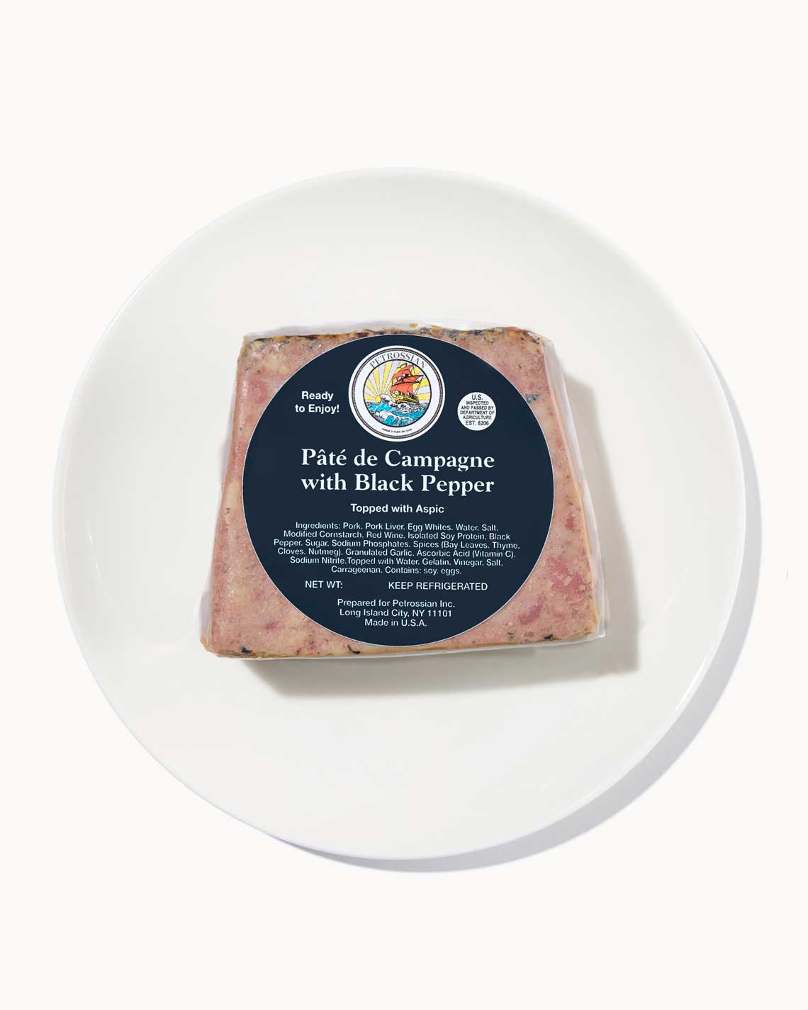 a full loaf of pepper pate ona white plate with a Petrossian label