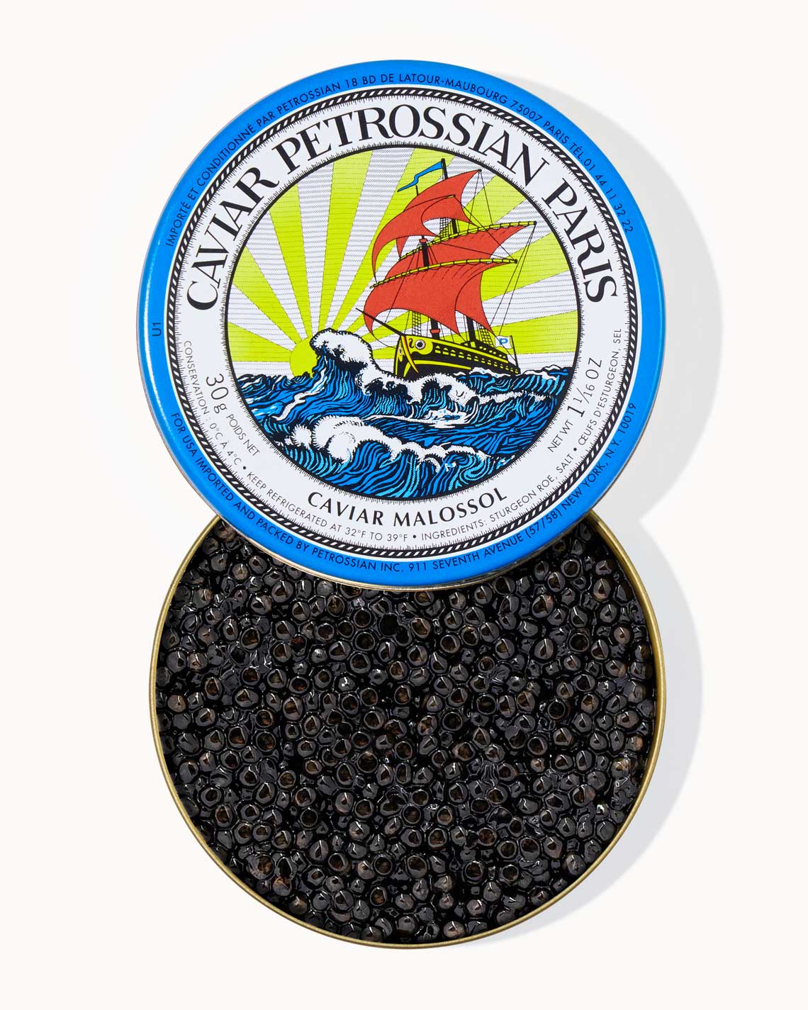 a top-down shot of a blue Petrossian caviar tin filled with shiny black beads of delicious caviar inside. The tine shows the Petrossian logo of a sailing ship on the high seas.